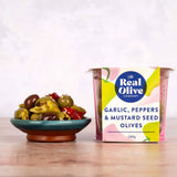 A vibrant container of real olive company garlic peppers and mustard seed stuffed green olives with pitted green olives
