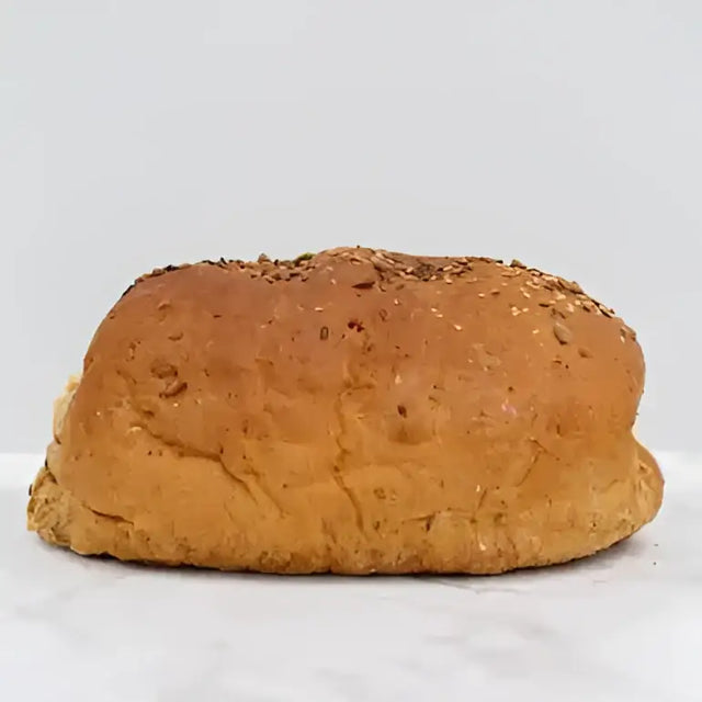 Golden brown multseed bread with a textured cracked surface and dark seeds perfect for blood sugar control