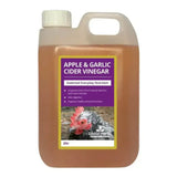 A 2-liter jug of global herbs apple garlic cider vinegar with white cap and handle containing amber liquid for chickens