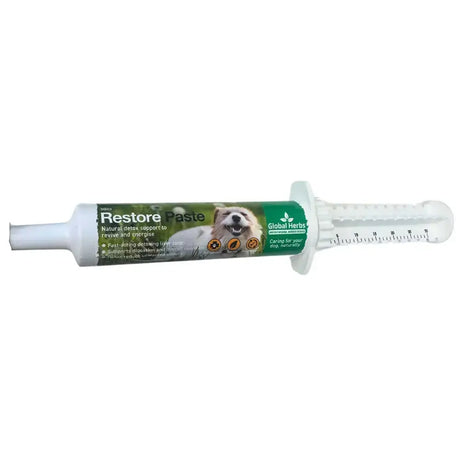 White plastic syringe tube of global herbs canine restore paste with green dog label and measurement markings