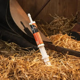 White plastic syringe with orange and black label reading supracalm resting on straw for global herbs supercalm instant syringe calming herbal mix