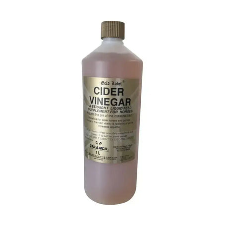 A 1 liter bottle of gold label cider vinegar with translucent pinkish liquid and gold cap for laminitic horses