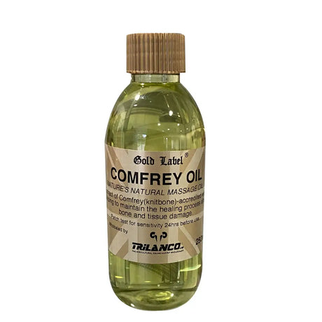 A clear glass bottle with bamboo cap containing trilanco gold label comfrey oil for horse care comfrey oil