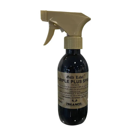 A dark glass bottle with beige spray nozzle labeled gold label purple plus aloe vera spray for minor cuts by trilanco