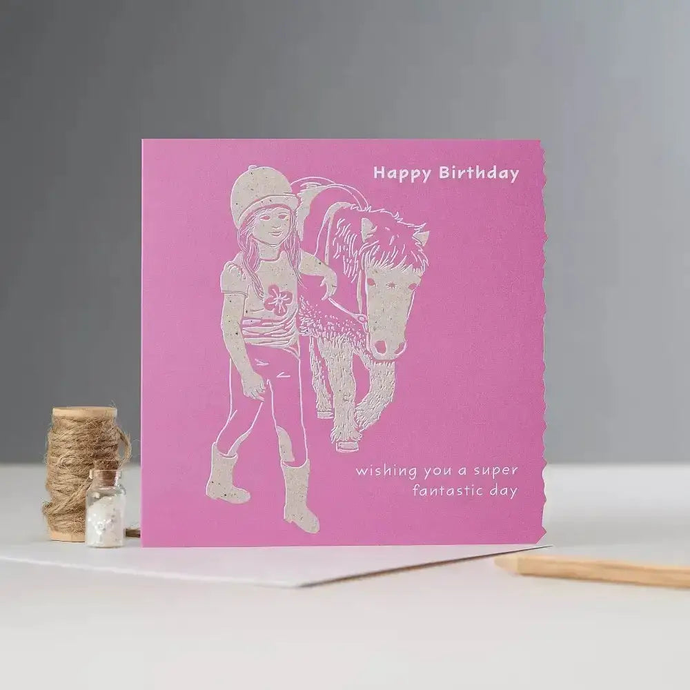 Pink happy birthday card with white laser-cut girl in riding gear and pony illustration individually cello wrapped pony card