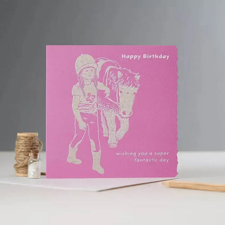 Pink happy birthday card with white laser-cut girl in riding gear and pony illustration individually cello wrapped pony card