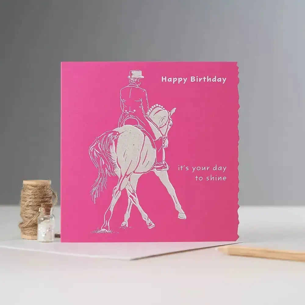 A vibrant pink happy birthday card with white textured line-art of an equestrian rider blank inside individually cello wrapped
