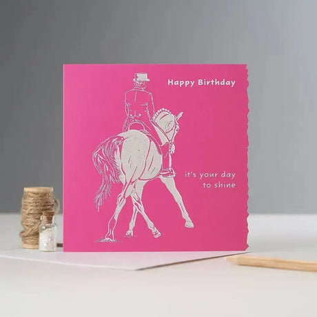 A vibrant pink happy birthday card with white textured line-art of an equestrian rider blank inside individually cello wrapped