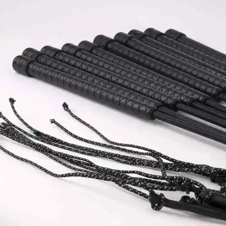 Black leather harlequin lunge whip with textured grip and braided black and white cord for quality riding crops use