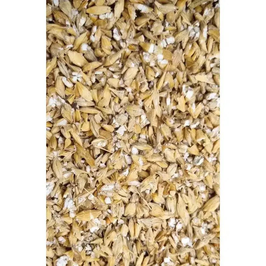 A pile of golden brown dried malted grains with white powdery residue in henrys rolled barley micronised product