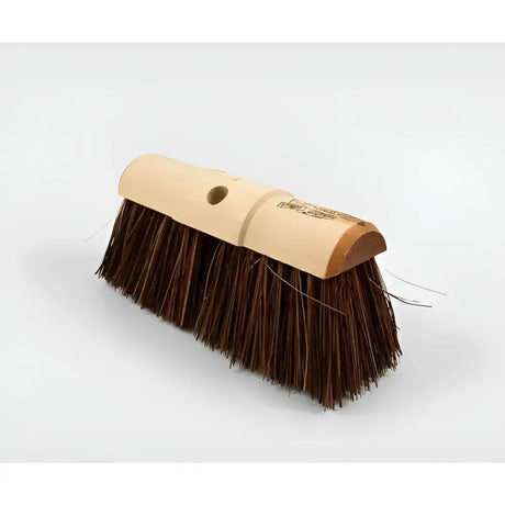 A hillbrush industrial stiff yard broom head with a light brown wooden handle and dense dark brown stiff bristles