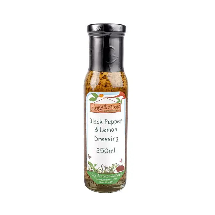 A clear glass bottle with black cap containing hogs bottom black pepper and lemon dressing 250ml