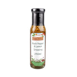 A clear glass bottle with black cap containing hogs bottom black pepper and lemon dressing 250ml