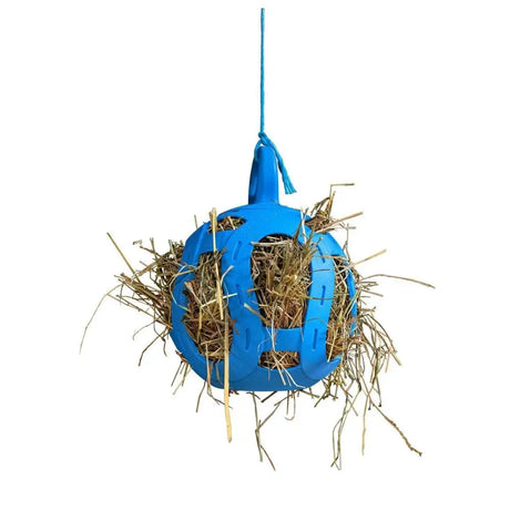 Blue plastic horsemen’s pride jolly hay ball filled with straw for feeding horses and pets