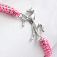 A silver metal horse centrepiece on a pink braided adjustable cord horsey friendship bracelet