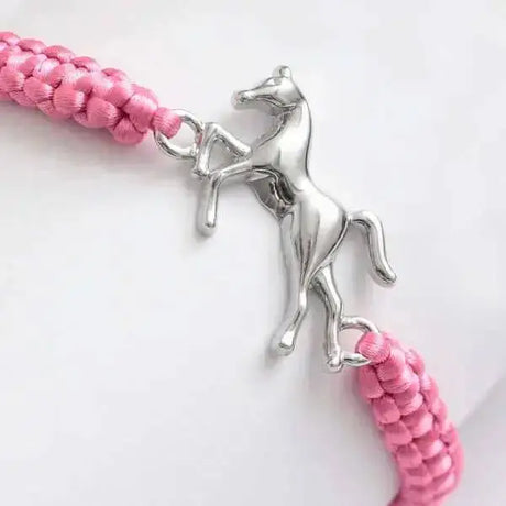 A silver metal horse centrepiece on a pink braided adjustable cord horsey friendship bracelet