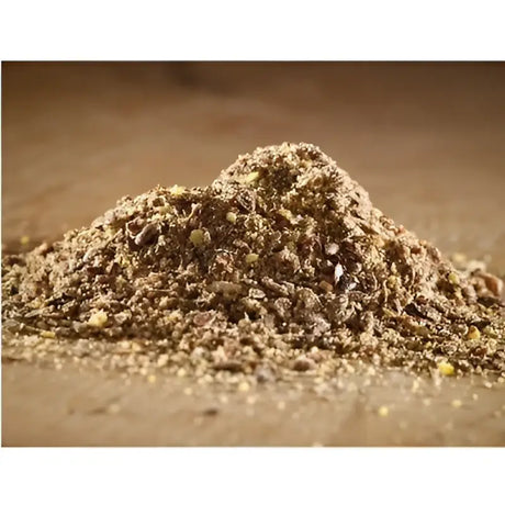 A mound of brown granular cooked linseed meal with specks used as fish bait from hutton mill