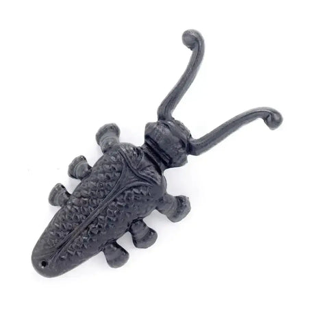 Black cast iron beetle boot jack shaped like a beetle with textured body and curved antennae for equestrian boot use
