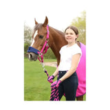 A vibrant pink horse halter with navy blue noseband and braided lead rope paired with belton children’s riding gloves