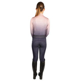 A woman wearing hy equestrian elevate allure mizs ombre base layer in gradient pink to purple with dark gray grip riding pants