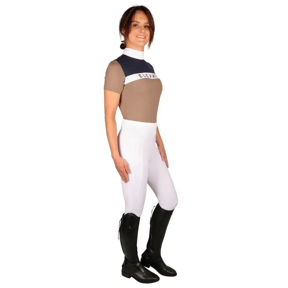A woman wearing a navy beige and white equestrian elevate allure show shirt with elevate printed on the chest