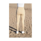 Beige hy equestrian fordwich riding tights with four-way stretch fabric worn with white sneakers on sandy surface