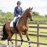 A sleek chestnut horse with black mane wearing white leg wraps and a dark bridle showcasing the roka regal show jacket