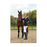 A woman in hy equestrian silvia jacket ladies made of technical material stands beside a brown horse with black bridle