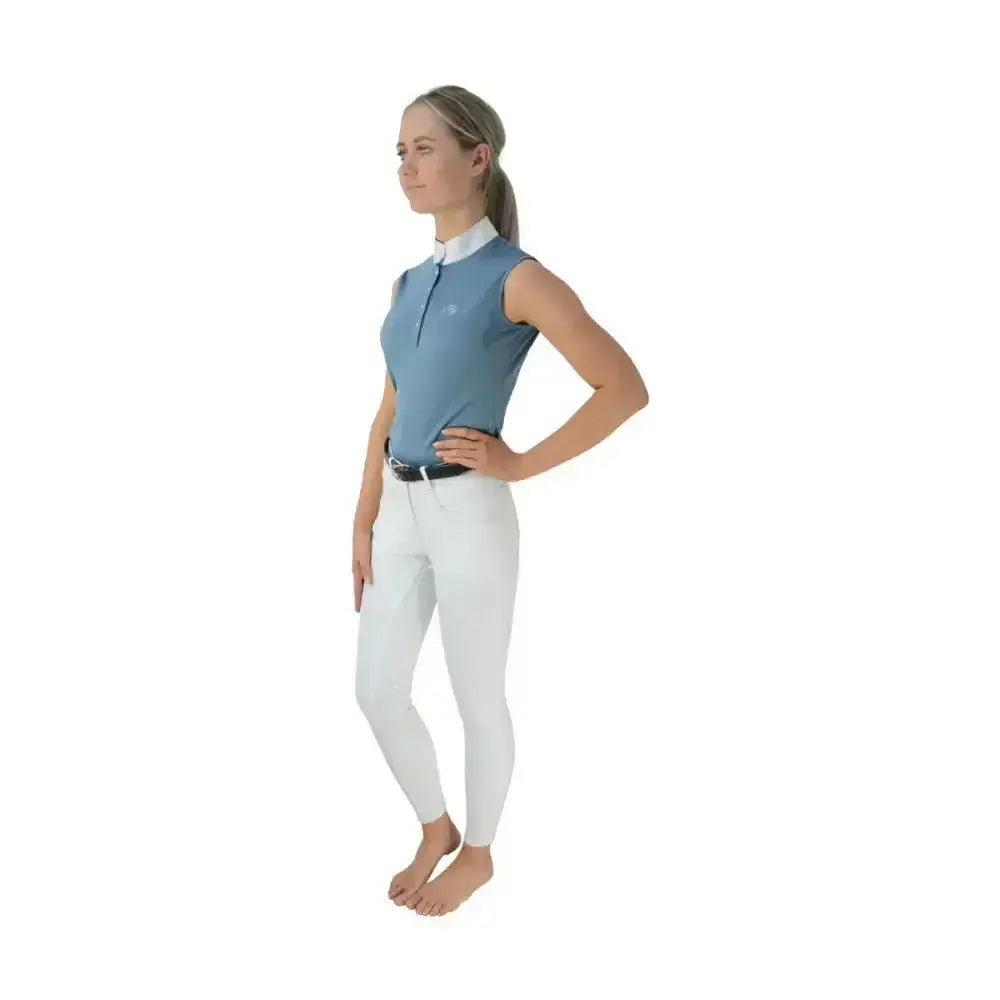 A woman wears a light blue hy equestrian sophia sleeveless shirt with five crystal press and silk trim detailing