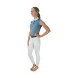 A woman wears a light blue hy equestrian sophia sleeveless shirt with five crystal press and silk trim detailing