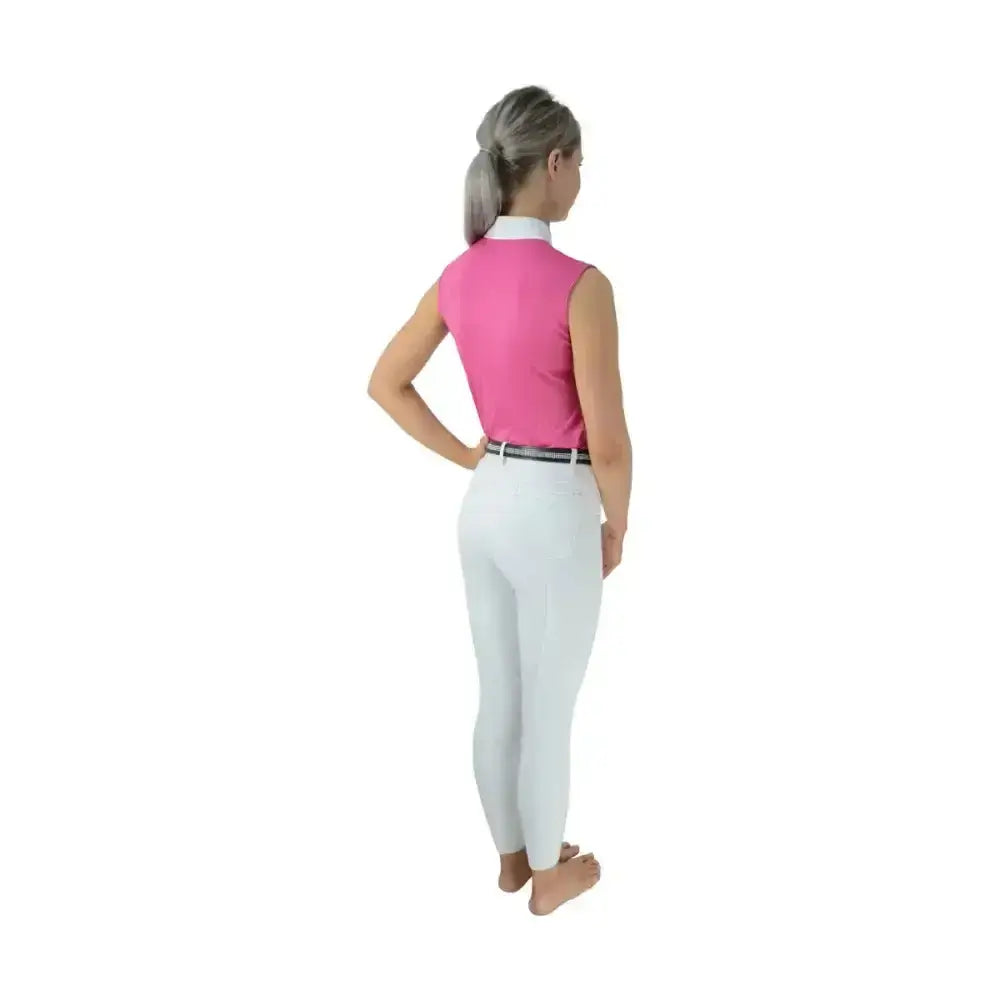 A woman wearing hy equestrian sophia sleeveless show shirt rose pink with crystal press studs and silk trim detailing