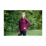 A woman wears a vibrant magenta hy equestrian synergy cowl long-sleeved hoodie with a cozy cowl neck line and drawstrings