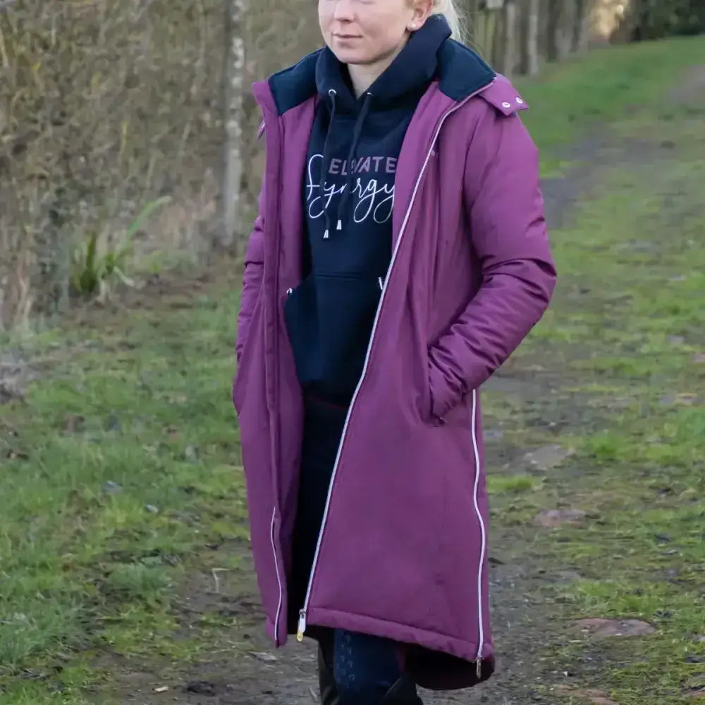 A long quilted purple fitted long waterproof parka with navy blue hood and white zipper trim from hy equestrian synergy guard
