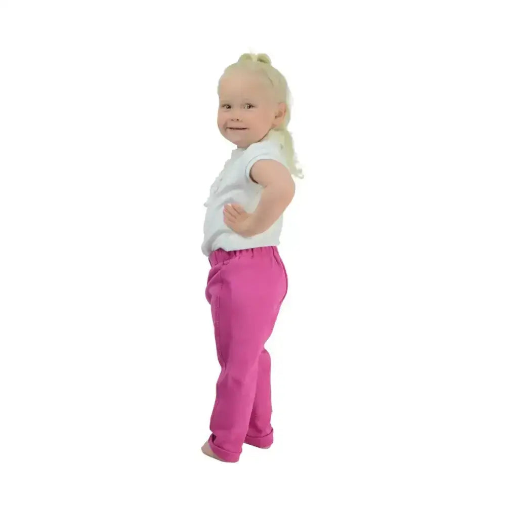 A toddler wearing bright pink soft stretchy hy equestrian zeddy tots pull-on tots jodhpur pants with rolled cuffs
