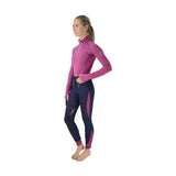A woman wearing a close fit hy sport active base layer in vibrant magenta with soft breathable fabric details