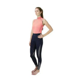 A woman in a coral hy sport active sleeveless top paired with navy blue leggings from the sport active collection base layers