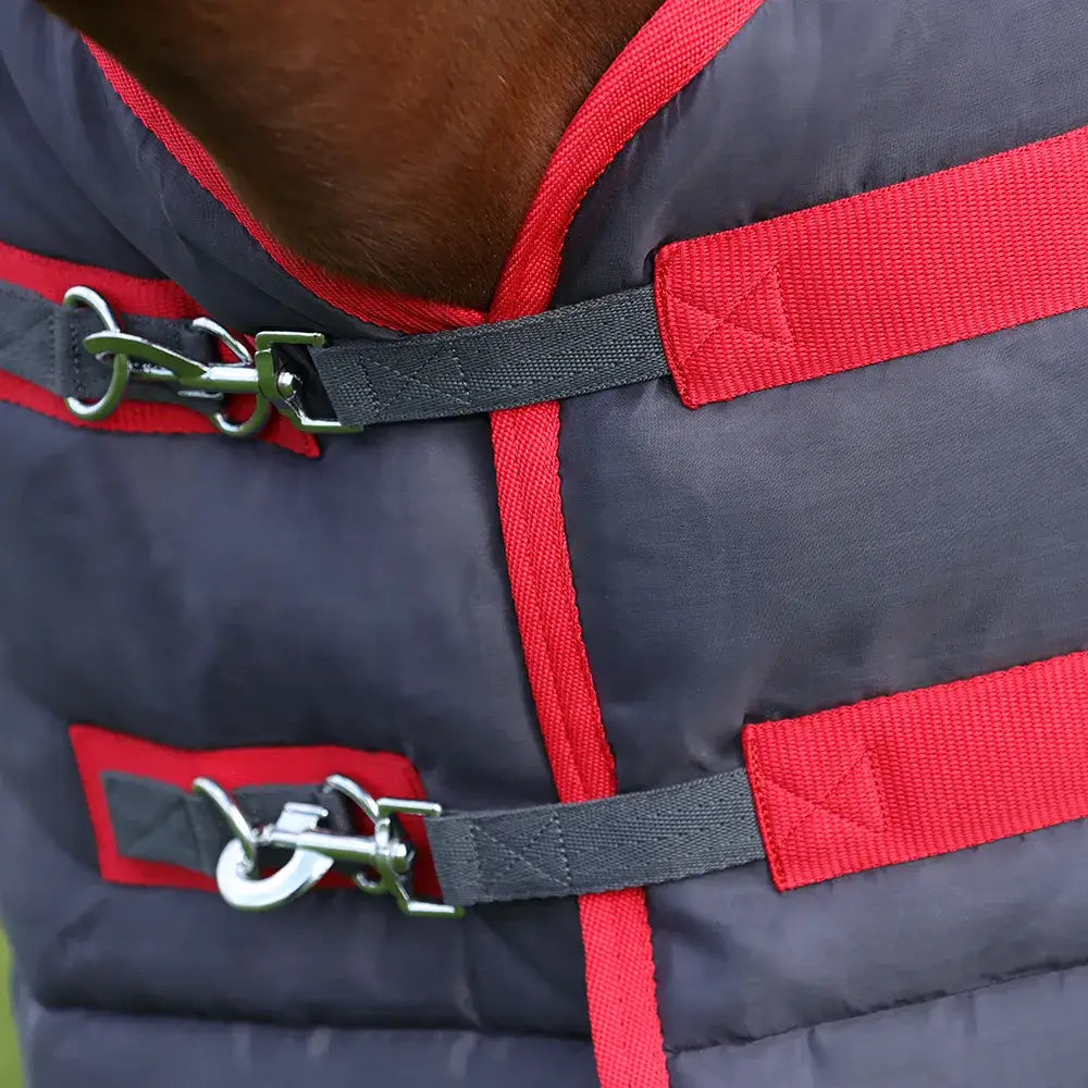 Dark gray quilted hyconic 100g stable rug with red trim black straps and silver buckles for horse warmth and comfort