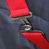 Red webbing strap with metallic hyconic buckle attached to dark gray fabric on the hyconic 100g stable rug