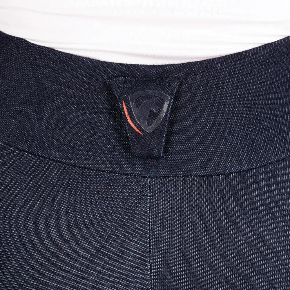 Dark blue textured fabric collar with black brand tag and orange line on hyconic valloria denim riding tights
