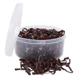 A clear container filled with dark brown imperial riding plaiting silicone bands soft spilling onto the surface