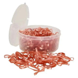 A clear plastic container of rose gold imperial riding plaiting silicone plaiting bands spilling over the edge