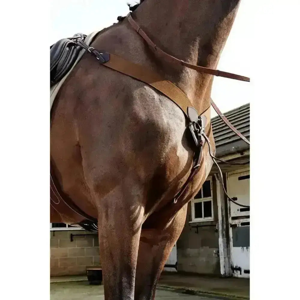 Brown leather horse saddle with black accents and metal hardware for john whitaker ready ride elastic breastplate use