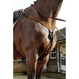 Brown leather horse saddle with black accents and metal hardware for john whitaker ready ride elastic breastplate
