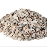 A pile of muted beige gray and subtle orange heygates poultry oyster shell grit fragments for poultry oyster shell use