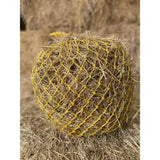 A round hay ball in a bright yellow extra strong polyethylene elite deluxe haynet for durable feeding