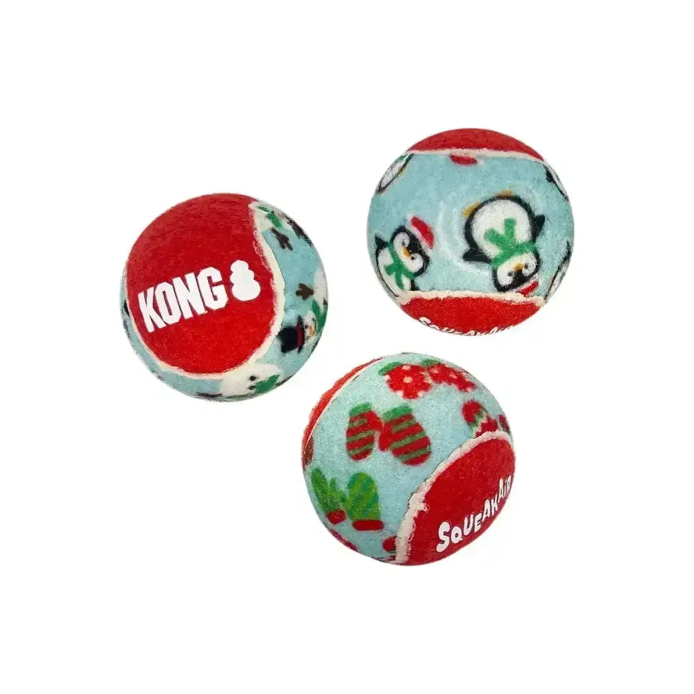 Three kong holiday squeakair balls with red and blue holiday patterns like penguins in hats and mittens