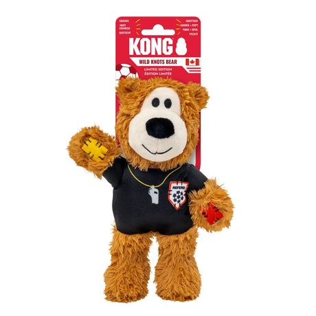 A brown plush kong wild knots bear toy wearing a black knots sport ref shirt with red and white patches ref bear referee