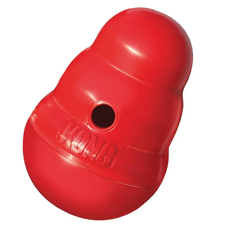 Red kong wobbler dog treat dispenser with glossy plastic surface and embossed logo periodically dispenses tasty rewards