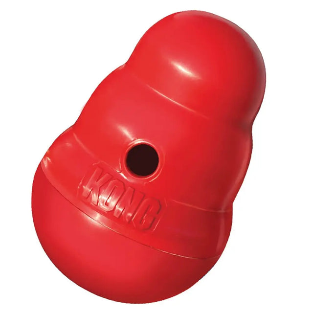 Red kong wobbler dog treat dispenser with glossy plastic surface and embossed logo periodically dispenses tasty rewards