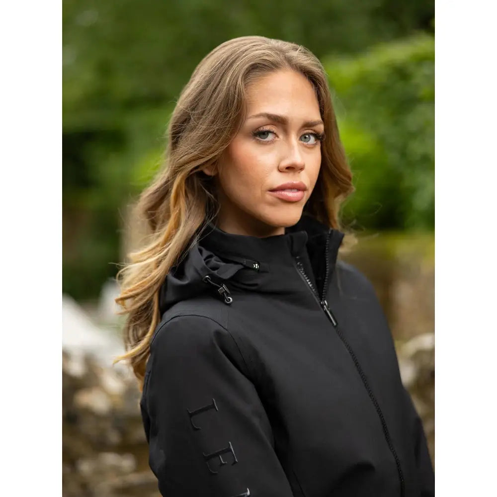 Black hooded ladies team jacket with subtle branding on the sleeve perfect for casual team wear in black